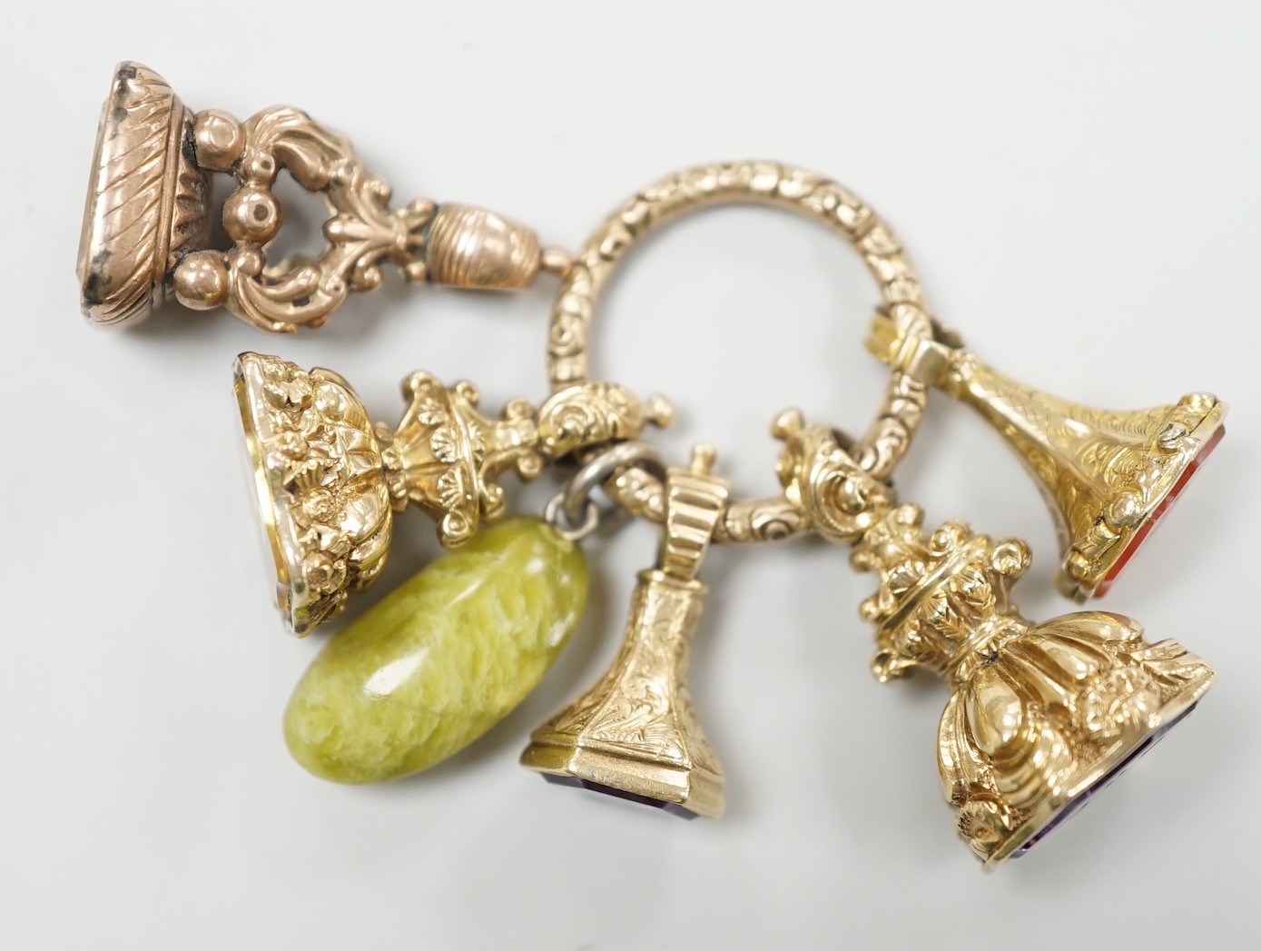 Four Victorian assorted yellow metal and gem set fob seals, including two amethyst(one carved with initials), one citrine and one carnelian (carved with monogram), together with a stone? charm and a gold plate mounted ci